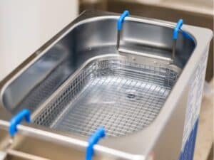 Macchinario professionale per pulizia a ultrasuoni con cestello in acciaio inox per uso industriale.